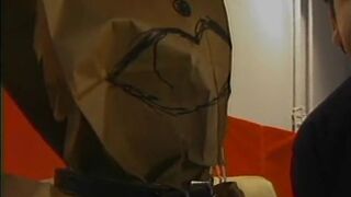 Chubby whore with paper bag on head has her jugs and cunt